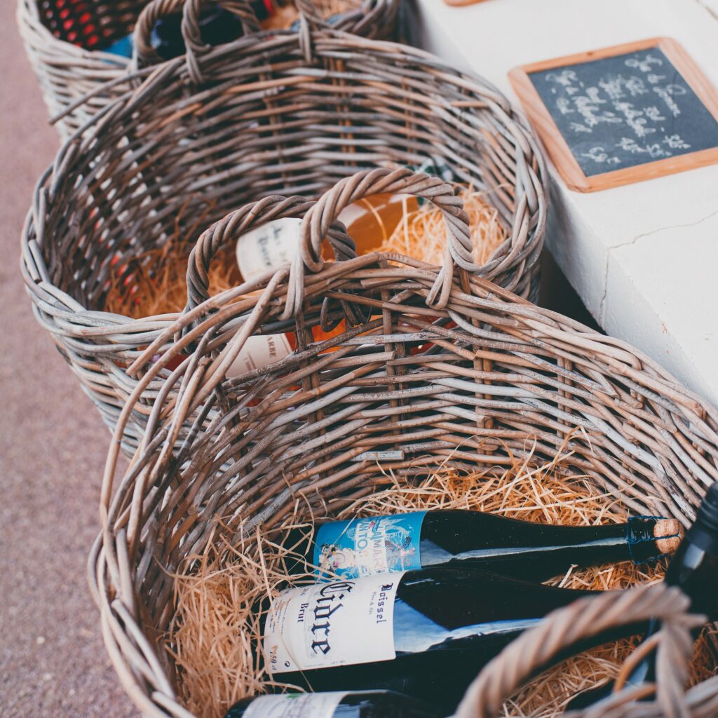 Image bouteilles de vin rouges, vins blancs, vins d'appellation, vins de terroirs, vins de vignerons dans des paniers sur un marché du vin. 